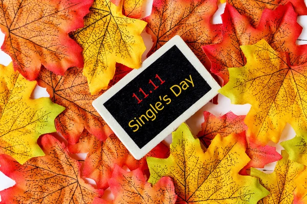 Online shopping of China, 11.11 single\'s day sale concept. Mini blackboard for text and maple leaf with text 11.11 single\'s day sale on white background.