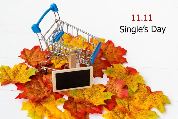 Single\'s day sale concept of China, 11.11. The shopping cart on maple leaf and text 11.11 single\'s day sale with copy space.