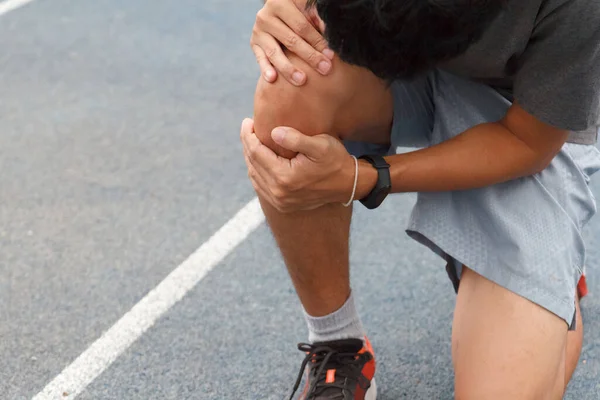 Sport man suffering with pain on sports running knee injury after running.Injury from workout concept.