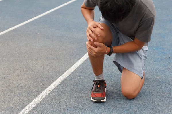 Sport man suffering with pain on sports running knee injury after running.Injury from workout concept.