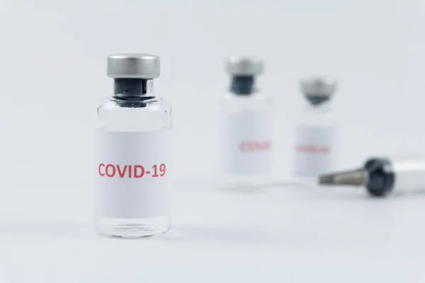 Beyaz arka planda şişe içinde Corona virüs aşısı, COVID19