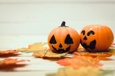 Ahşap bir masada boyanmış yüzleri olan Cadılar Bayramı balkabakları. Cadılar Bayramı geçmişi. Mesaj için yer var. Boşluğu kopyala.