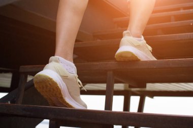 Kadının yakın çekimi merdivenlerde yürür. adım adım yürü