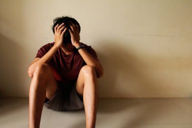 üzgün genç bir adam boş bir odada yalnız başına oturuyor, üzgün, yalnız, toyluk, ergenlik, ev şiddeti, istenmeyen aşk sorunları, yalnız, aile