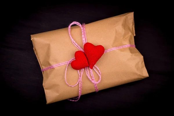 Papiertüte, Geschenk, mit rosa Faden auf schwarzem Hintergrund gebunden, cr — Stockfoto
