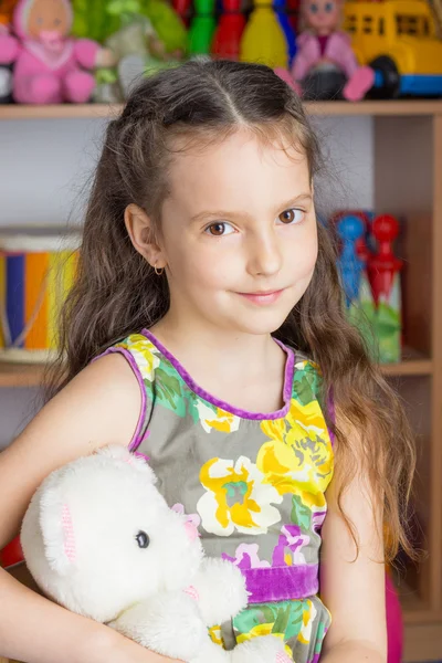 Kız 6 yaşındaki esmer, renkli elbise, oyuncak beyaz ayı — Stok fotoğraf