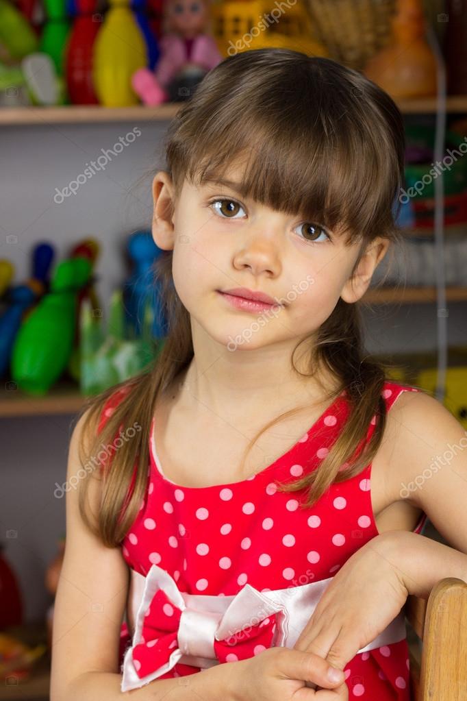 6 years old girl blond hair, red dress with white polka dots Stock Photo by  ©nazarulika 70446009