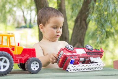 küçük bir çocuk, gülümseyen, iki yaşında, bel çıplak yaz