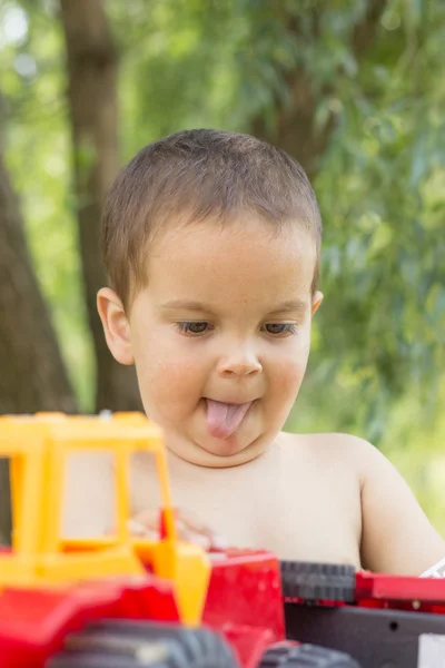 Un niño pequeño, de dos años, sonriente, de verano, desnudo hasta la cintura — Foto de Stock