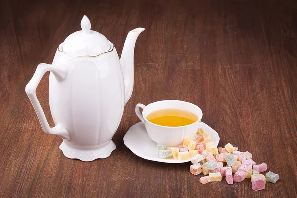 Tea in a white cup and saucer, a scattering of Turkish Delight — Stock Photo, Image