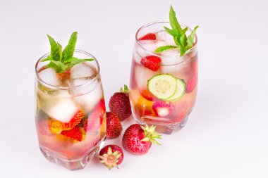 çilek toplu beyaz bir arka plan üzerinde bir bardak içki ile