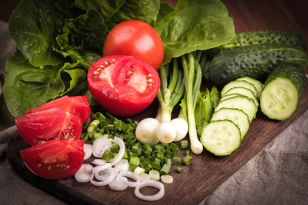 Ung grön lök, ung grön gurka, tomat, sallad på en wo — Stockfoto