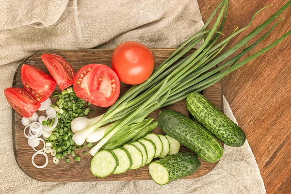 Ung grön lök, ung grön gurka, tomat, sallad på en wo — Stockfoto