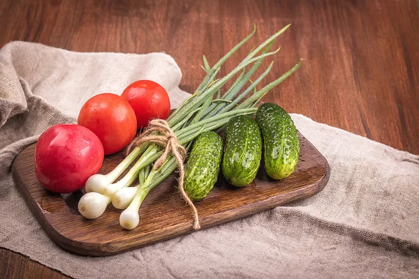 Ung grön lök, ung grön gurka, tomat, sallad på en wo — Stockfoto