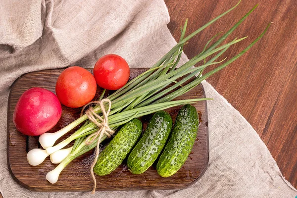 Genç yeşil soğan, genç yeşil salatalık, domates, marul üzerinde bir wo — Stok fotoğraf