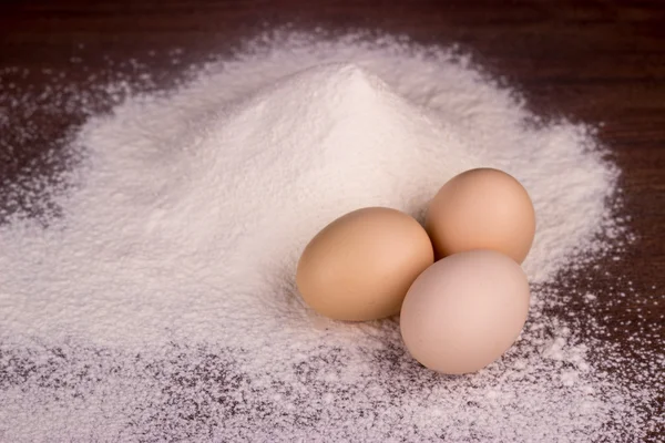 Tavuk yumurta ve un ahşap bir masa üzerinde — Stok fotoğraf