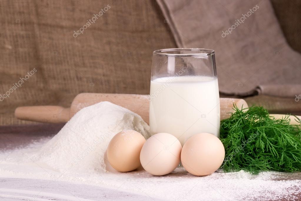 glass cup with milk, a glass bowl with cottage cheese, eggs, flo