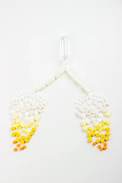 Tablets on a white background in white, yellow, orange syringe w — Stock Photo, Image