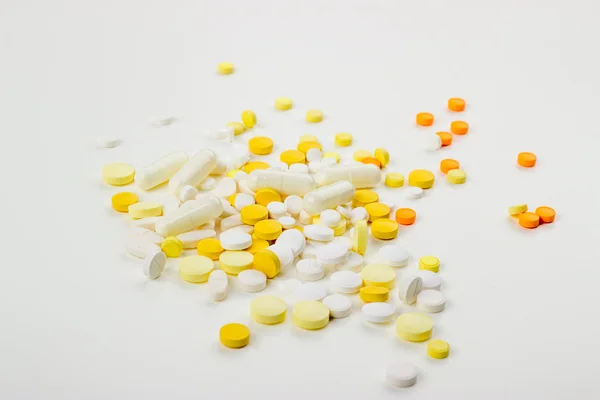 Tablets on a white background in white, yellow, orange, a syring — 图库照片