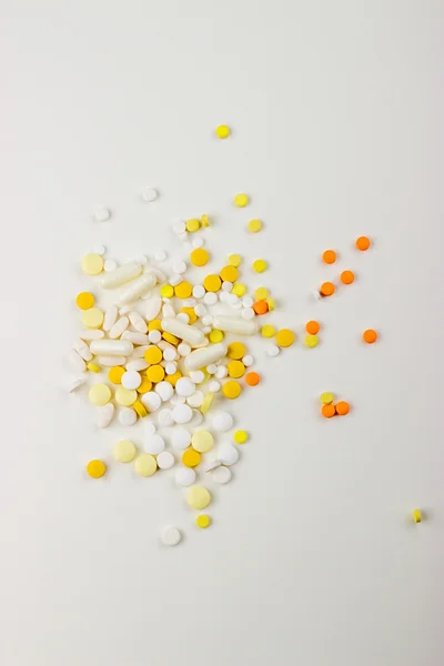 Tablets on a white background in white, yellow, orange, a syring — 图库照片