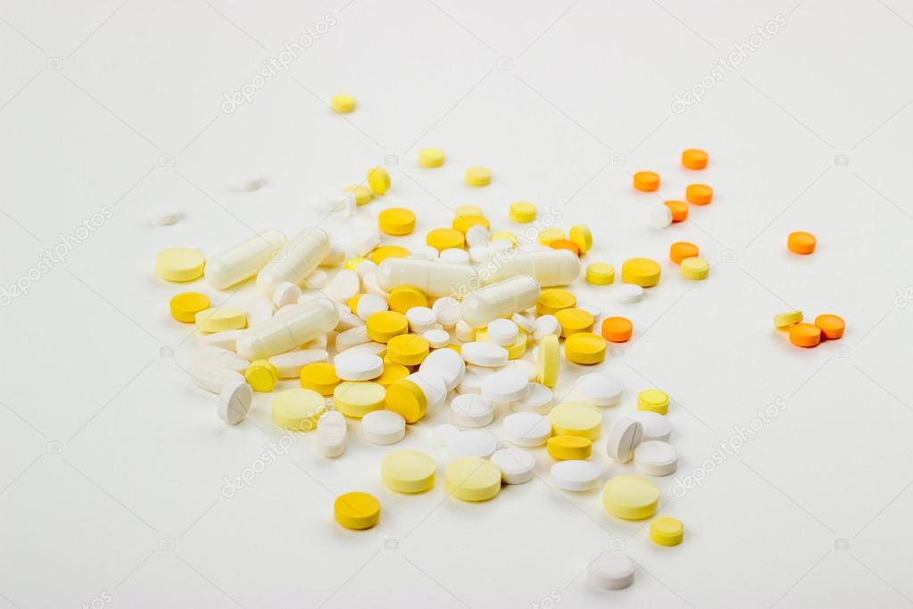tablets on a white background in white, yellow, orange, a syring
