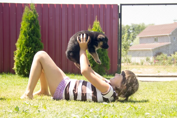 Joven, morena, jugando con cachorros pastor alemán en un —  Fotos de Stock