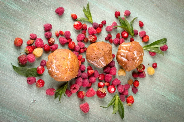 Muffins, scattered around the raspberries, strawberries, mint le — Stockfoto