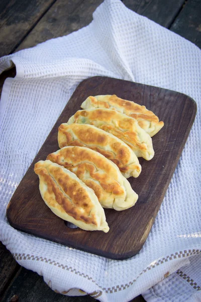 Fried pies on a wooden chopping board