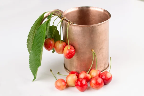 COPPER MUG with white cherries on a white background — Stock Photo, Image