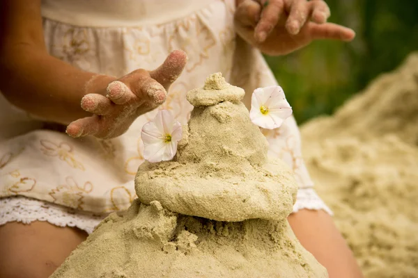 The hand of a little girl out of the sand mold cake — Stock Photo, Image