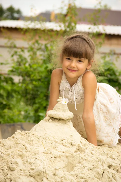 Маленькая девочка, брюнетка волосы плетены в легком платье играет в — стоковое фото