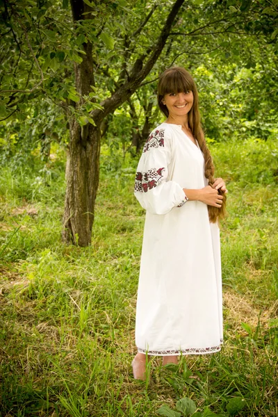 Young girl in the Ukrainian embroidered shirt, standing barefoot — ストック写真