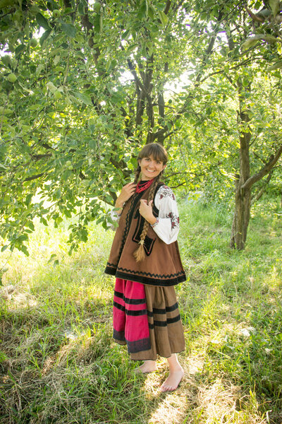 young girl, Ukrainian national costume, standing barefoot on the