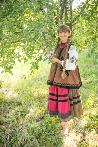 Young girl, Ukrainian national costume, standing barefoot on the — Zdjęcie stockowe