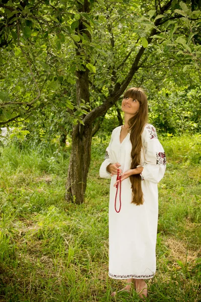 Young girl in the Ukrainian embroidered shirt, standing barefoot — Zdjęcie stockowe