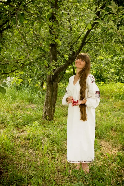 Young girl in the Ukrainian embroidered shirt, standing barefoot — Zdjęcie stockowe