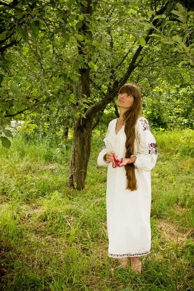 Молодая девушка в украинской вышитой рубашке, стоящая босиком — стоковое фото