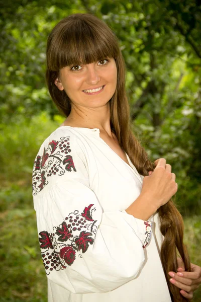 Young girl in the Ukrainian embroidered shirt, standing barefoot — Stockfoto