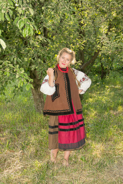 young girl, Ukrainian national costume, standing barefoot on the