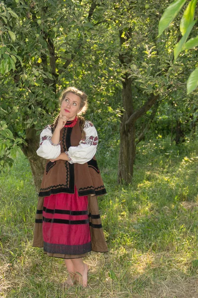 Young girl, Ukrainian national costume, standing barefoot on the — Stock fotografie