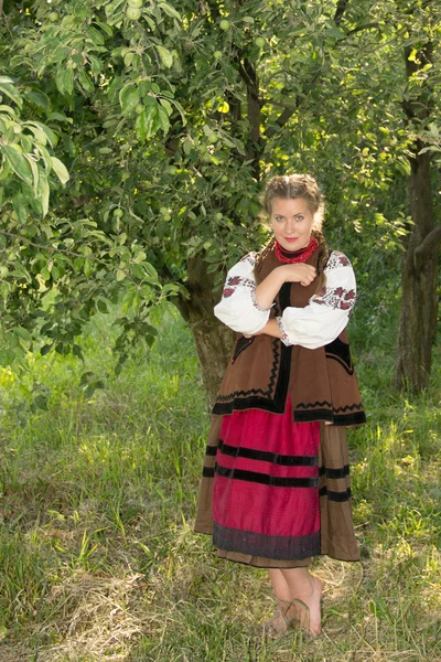 Young girl, Ukrainian national costume, standing barefoot on the — Stok fotoğraf