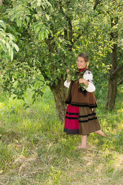 young girl, Ukrainian national costume, standing barefoot on the