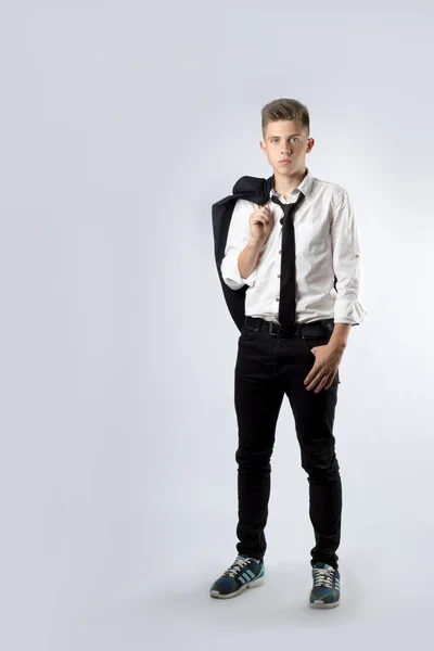 A young boy, brunette student in a black suit on a white background — Stock Photo, Image