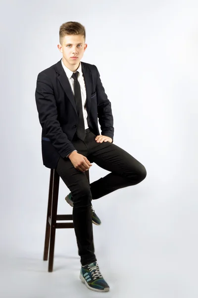 Genç bir çocuk, kısa saçlı, siyah takım elbiseli bir öğrenci esmer