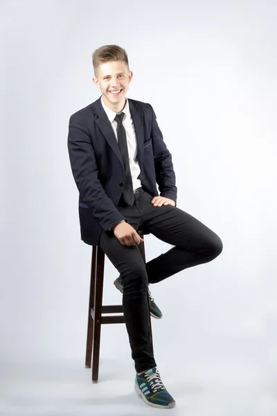 Genç bir çocuk, kısa saçlı, siyah takım elbiseli bir öğrenci esmer