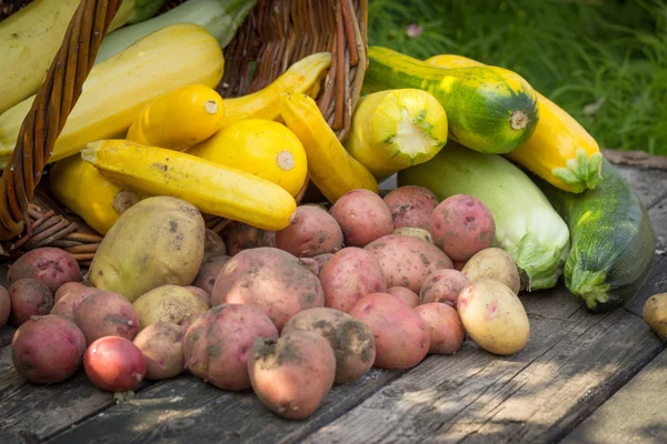 Jaune, courgettes vertes, pommes de terre, sol taché sur vieux t en bois — Photo