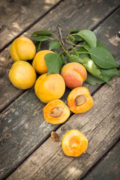 Abricots frais éparpillés sur la vieille table en bois — Photo