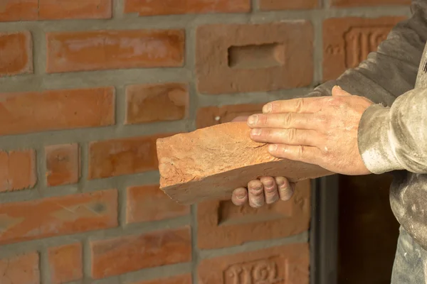 Men's hands are kept carved brick on brick wall background, man' — Φωτογραφία Αρχείου