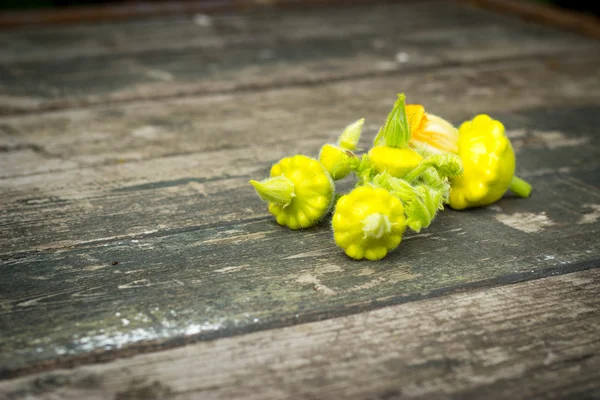 Patisson pequeno amarelo, abóbora laranja em uma aba velha redonda de madeira — Fotografia de Stock