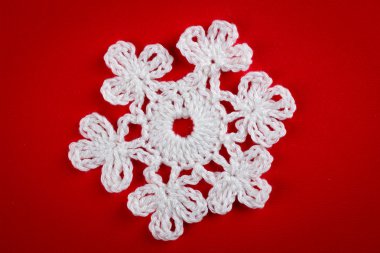 kırmızı bir arka plan üzerinde beyaz iplik kar taneleri tığ işi